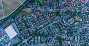 Die B-Lage – Immobilie tatsächlich erschwinglicher kaufen? - SATHI-Immobilien Luftbild eines deutschen Ortes | Immobilienkauf